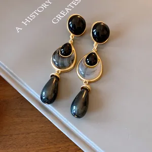Detailed view of vintage black stone earrings with elegant gold trim in teardrop shape