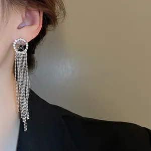 Eleganti orecchini lunghi con nappa e stella di strass, primo piano sul modello