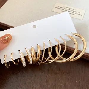 Nahaufnahme eines vielseitigen 9-Paar Goldohrring-Sets mit eleganten Perlen und Ringen