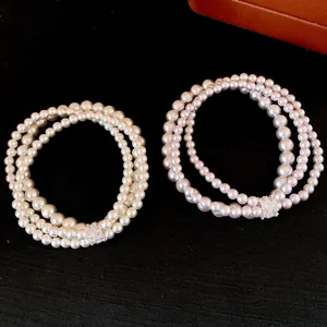 Detailed view of two elegant multi-strand pearl bracelets with shimmering zircon clasps.