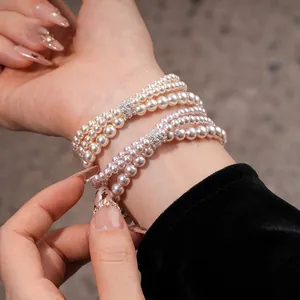 Elegant multi-strand pearl bracelets featuring shimmering zircon spacers on woman's wrist