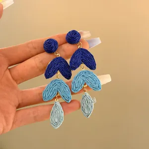Detailed close-up of blue gradient raffia earrings showing hand-woven texture