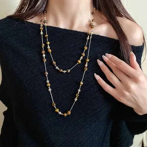 Elegant vintage tiger eye beaded layered necklace for women on a black sweater background