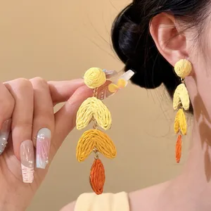 Handmade raffia leaf drop earrings with yellow and orange woven textures