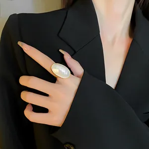 Elegant close-up view of a large oval pearl statement ring with gold plating finish