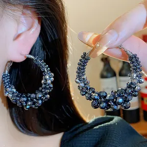Detailed view of vintage style beaded hoop earrings with faceted dark glass beads