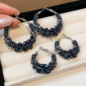 Macro view of elegant vintage hoop earrings with faceted navy blue glass beads.