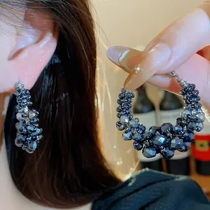 Detail view of vintage beaded hoop earrings with faceted black glass and silver needles.