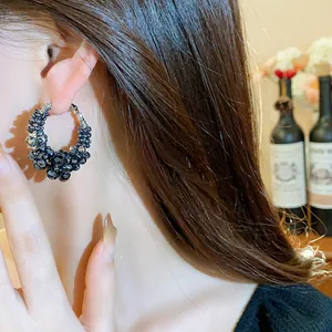 Close-up detail of vintage black glass bead hoop earrings for an elegant luxury look.