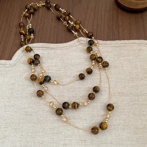 Close-up of a multi-layer tiger eye stone beaded necklace with golden bead accents.