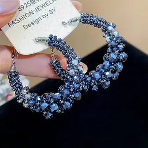 Detail view of deep blue beaded hoop earrings with vintage faceted glass crystals