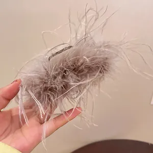 Close-up detail of a fluffy grey ostrich feather hair claw clip for elegant bun styling