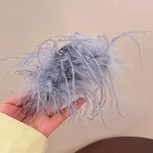 Detailed view of the soft grey ostrich feather hair claw clip for elegant bun styling