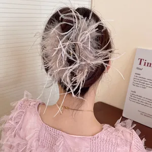 Close-up detail of an elegant gray feather hair claw clip styled on a woman's low bun
