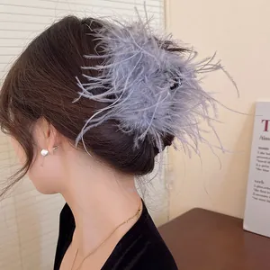 Elegant grey feather hair claw clip for bun hairstyles on an Asian model.