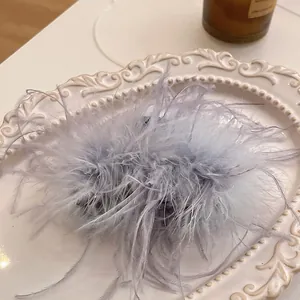 Close-up of light purple fluffy feather hair claw clip on an ornate white plate