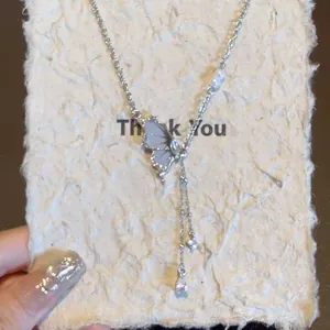 Dettaglio della collana a farfalla in zircone con nappe eleganti e accenti di perle