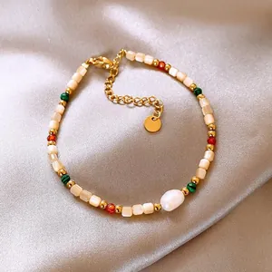 Detail showing 18K gold plated beads, shell pieces, and white baroque pearl on satin fabric.
