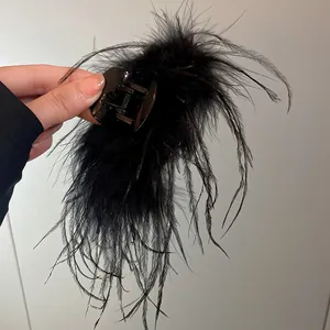 Elegant black feather hair claw clip with multi-layered design for women's hairstyle