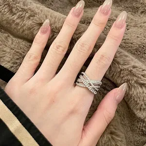 Elegant silver-toned criss-cross open ring with sparkling cubic zirconia on hand
