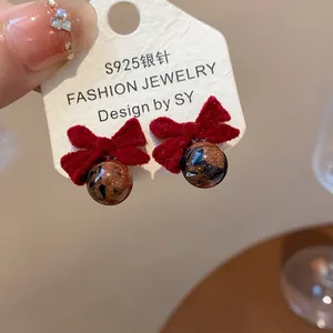 Primo piano di orecchini a fiocco rosso floccato con aghi in argento S925 e sfera glitter