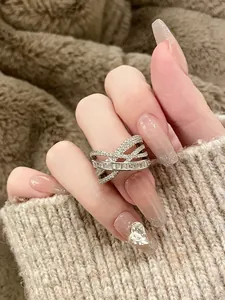 Detailed close-up view of a silver crisscross ring with sparkling cubic zirconia stones