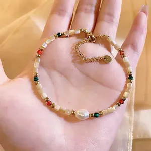 Macro view of a handmade 18K gold plated shell and pearl beaded bracelet on a hand