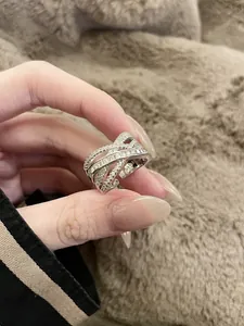 Detailed view of a criss-cross open ring featuring sparkling zirconia stones.