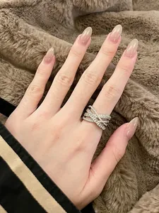 Detailed view of silver-toned criss-cross adjustable ring with pavé and baguette zircons
