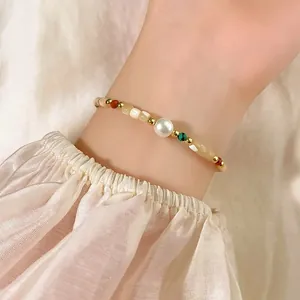 Elegant detailed view of 18K gold plated shell pearl beaded bracelet worn on a female wrist
