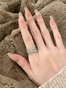Elegant silver crisscross ring with shimmering cubic zirconia worn on the index finger