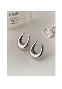 Detailed macro view of minimalist polished silver water-drop hoop earrings on clean background