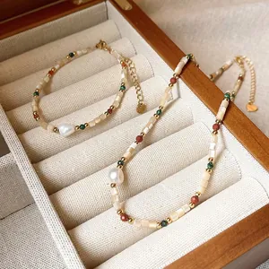 Close-up of 18K gold plated shell and pearl beaded jewelry set in a wooden box