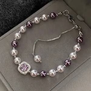 Close-up of a French vintage pearl bracelet with a purple gemstone and adjustable chain