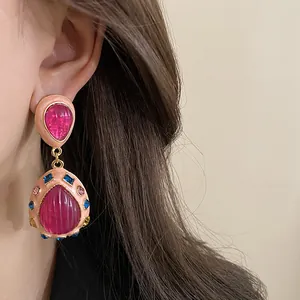Detailed macro view of vintage pink teardrop earrings with colorful rhinestone accents