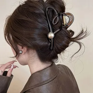 Vue détaillée d'une pince à cheveux géométrique marron café avec perle sur modèle