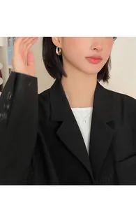 Silver metallic smooth oval waterdrop hoop earrings worn by model in professional black blazer