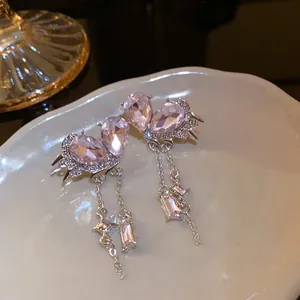 Detailed view of vintage pink waterdrop earrings with silver chain tassels and crystals.