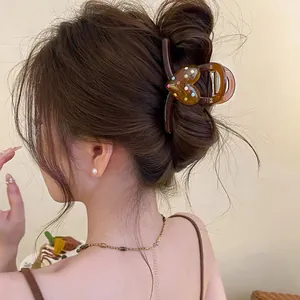 Vue détaillée d'une pince à cheveux marron rétro avec un motif de cœur coloré élégant