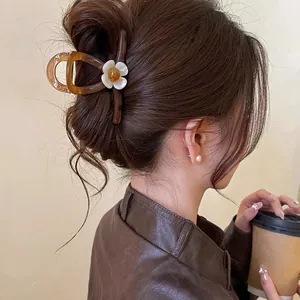 Gros plan sur une pince à cheveux rétro française marron avec fleur blanche chic