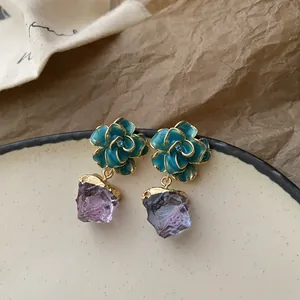 Detailed view of vintage teal flower earrings with purple rough stone pendants