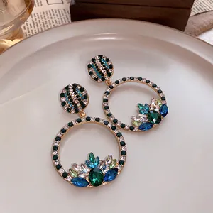 Detailed view of vintage palace style round hoop earrings with colorful crystals
