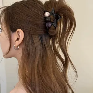 Vue détaillée d'une pince à cheveux étoile marron de style français avec perles sur une queue