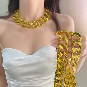 Close-up of chunky gold acrylic chain necklace on model with punk fashion style.