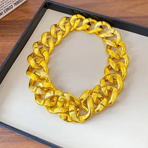 Detailed macro view of a chunky golden acrylic chain necklace on a minimalist display