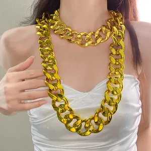 Close-up detail of chunky gold acrylic chain necklace in punk style worn by model