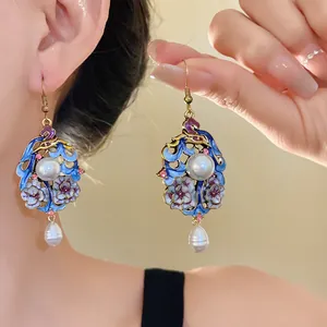 Detailed view of vintage floral earrings with blue enamel and teardrop pearls.