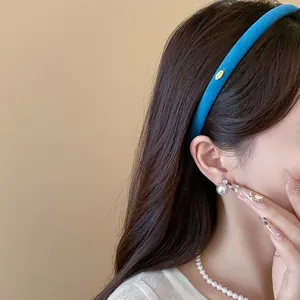 Close-up detail shot of a minimalist blue velvet thin headband worn by an Asian model