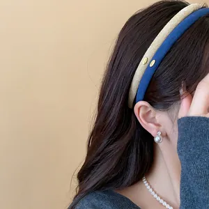 Detailed side view of a model wearing elegant blue and beige flocked thin headbands with gold accents.