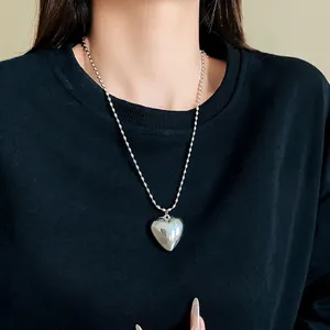 Minimalist silver rice grain chain necklace with a smooth heart pendant for women.
